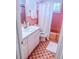 Retro bathroom with pink tile, a white vanity, a toilet, and a shower-tub combo at 2001 Lily Ct, Sanford, FL 32771