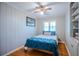 Cozy bedroom with wood floors, paneled walls, ceiling fan, and a bright window with shutters at 2001 Lily Ct, Sanford, FL 32771