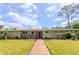 Charming single-story home featuring a brick facade, well-manicured lawn, and inviting walkway at 2001 Lily Ct, Sanford, FL 32771
