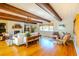 Open-concept living room with hardwood floors, beamed ceilings, and a cozy fireplace at 2001 Lily Ct, Sanford, FL 32771