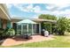 Outdoor patio area with brick pavers, a dining set, and lush landscaping perfect for outdoor dining and relaxation at 2001 Lily Ct, Sanford, FL 32771