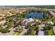 Beautiful aerial view of community pool and lake featuring a fountain, clubhouse, lush landscaping, and ample parking at 2030 Majorca Dr, Kissimmee, FL 34747