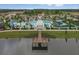 Stunning aerial view of the community pool, clubhouse, and amenities set amongst lush landscaping and a scenic lake at 2030 Majorca Dr, Kissimmee, FL 34747