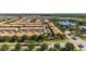 Community aerial view showcasing multiple buildings and residences, a pool, a lake, trees, and the overall neighborhood layout at 2030 Majorca Dr, Kissimmee, FL 34747