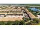 Community aerial view showcasing multiple buildings and residences, a pool, a lake, trees, and the overall neighborhood layout at 2030 Majorca Dr, Kissimmee, FL 34747