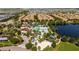Community aerial view showcasing multiple buildings and residences, a pool, a lake, trees, and the overall neighborhood layout at 2030 Majorca Dr, Kissimmee, FL 34747
