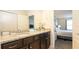 Bathroom featuring a dual sink vanity with granite countertop, next to bedroom at 2030 Majorca Dr, Kissimmee, FL 34747