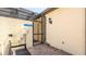 A screened-in entrance leads to the pool area with a warning sign, bench and exterior light fixture at 2030 Majorca Dr, Kissimmee, FL 34747