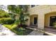 Exterior of a townhome featuring tropical landscaping, a brick walkway, and a covered entryway at 2030 Majorca Dr, Kissimmee, FL 34747