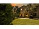 Home exterior featuring lush landscaping and a well-manicured lawn at sunset at 2030 Majorca Dr, Kissimmee, FL 34747