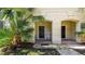 Inviting front porch with tropical plants, a rocking chair, and dual entrances at 2030 Majorca Dr, Kissimmee, FL 34747