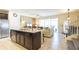 Open concept kitchen island with seating and stainless steel sink with living room and dining room views at 2030 Majorca Dr, Kissimmee, FL 34747