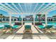 Luxurious pool area with lounge chairs, sun shades, and a beautiful clubhouse in the background at 2030 Majorca Dr, Kissimmee, FL 34747