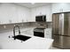 Well-lit kitchen with white cabinetry, stainless steel appliances, and updated countertops at 240 W Palmetto Ave, Deland, FL 32720