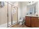 Bathroom with a glass-enclosed shower and wooden cabinets with neutral countertops at 257 Auburn Ave, Kissimmee, FL 34747