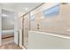 Bright bathroom featuring a glass-enclosed shower and neutral tile, accented by a window for natural light at 257 Auburn Ave, Kissimmee, FL 34747