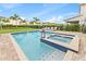 Sparkling pool and spa with a brick patio, lounge chairs, and lush landscaping at 257 Auburn Ave, Kissimmee, FL 34747