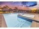 Twilight view of a sparkling pool and spa, surrounded by lush landscaping and patio at 257 Auburn Ave, Kissimmee, FL 34747