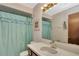 Traditional bathroom featuring a vanity with a single sink and a bathtub with a blue shower curtain at 2656 Whisper Lakes Club Cir, Orlando, FL 32837