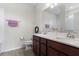 Bright bathroom featuring a double sink vanity with white countertop and wood cabinets and decorative wreath at 2723 Forestdale St, St Cloud, FL 34771
