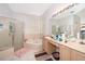 Bright bathroom featuring a bathtub, glass-enclosed shower, and a large vanity with double sinks at 2745 University Acres Dr, Orlando, FL 32817