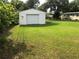 Large grassy backyard with a detached garage, and mature trees offering ample space at 2808 Drake Dr, Orlando, FL 32810