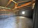 Spacious garage interior with exposed rafters, built-in shelves, and natural light at 2808 Drake Dr, Orlando, FL 32810