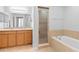 Bright bathroom with double sinks, a walk-in shower, and a soaking tub at 2829 Shady Willow Ln, Oviedo, FL 32765