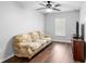 Neutral-toned room featuring a sofa, cabinet and hardwood floors under a ceiling fan, bathed in natural light at 2829 Shady Willow Ln, Oviedo, FL 32765