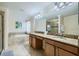 Bright bathroom featuring dual sinks, soaking tub, and separate glass-enclosed shower at 2999 Buccaneer Palm Rd, Kissimmee, FL 34747
