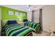 Bright bedroom features two twin beds, colorful decor, and a ceiling fan at 2999 Buccaneer Palm Rd, Kissimmee, FL 34747
