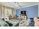 Comfortable living room with plush seating, large TV, ceiling fan and access to pool area at 2999 Buccaneer Palm Rd, Kissimmee, FL 34747