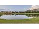 Scenic view of a pond reflecting nearby buildings and trees under a cloudy sky at 2999 Buccaneer Palm Rd, Kissimmee, FL 34747