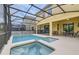 A beautiful screened in pool area with an adjacent jacuzzi and outdoor dining area with chairs at 2999 Buccaneer Palm Rd, Kissimmee, FL 34747