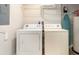 Functional laundry area with a washer, dryer, shelving, and ironing board at 3069 White Orchid Rd, Kissimmee, FL 34747
