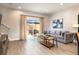 Cozy living room featuring neutral paint, wood floors, stylish decor, and natural light from a sliding glass door at 3069 White Orchid Rd, Kissimmee, FL 34747