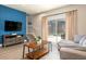 Living room featuring a blue accent wall, TV, and sliding glass doors to the outside at 3069 White Orchid Rd, Kissimmee, FL 34747