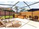 Enclosed patio featuring a hot tub, seating, and palm trees in view at 3069 White Orchid Rd, Kissimmee, FL 34747