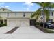 Inviting two-story townhome with attached two-car garage, well-manicured landscaping, and neutral exterior paint at 312 Arbor Lakes Dr, Davenport, FL 33896
