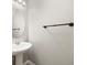 Clean half bathroom featuring a pedestal sink and a round mirror at 312 Arbor Lakes Dr, Davenport, FL 33896