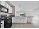 Bright kitchen boasts white cabinetry, black appliances, granite countertops, and an eat-in bar at 312 Arbor Lakes Dr, Davenport, FL 33896