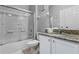Well-lit bathroom with granite counters, white cabinets, and shower-tub with sliding glass doors at 3193 Yellow Lantana Ln, Kissimmee, FL 34747
