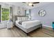 Bright bedroom with a large window, modern ceiling fan, and stylish gray striped wall at 3193 Yellow Lantana Ln, Kissimmee, FL 34747