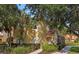 Inviting two-story exterior with lush landscaping, mature trees, and walkway to the front door at 3193 Yellow Lantana Ln, Kissimmee, FL 34747