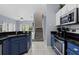 Kitchen with granite counters, blue cabinets, and stainless steel appliances, seamlessly flowing into the living area at 3193 Yellow Lantana Ln, Kissimmee, FL 34747