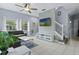 Open-concept living area with large windows, modern decor, and staircase at 3193 Yellow Lantana Ln, Kissimmee, FL 34747