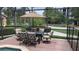 Outdoor patio with seating under a large umbrella surrounded by lush greenery at 3193 Yellow Lantana Ln, Kissimmee, FL 34747
