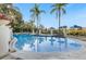 Large community pool with inviting blue water, palm trees and sun loungers at 3193 Yellow Lantana Ln, Kissimmee, FL 34747