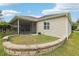 Backyard features a stone perimeter design, screen room, and grassy area perfect for enjoying the outdoors at 3198 Abana Path, The Villages, FL 32163
