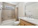 Bathroom with large tiled shower/tub, safety bar, frosted glass block window, updated vanity with a large mirror at 3198 Abana Path, The Villages, FL 32163